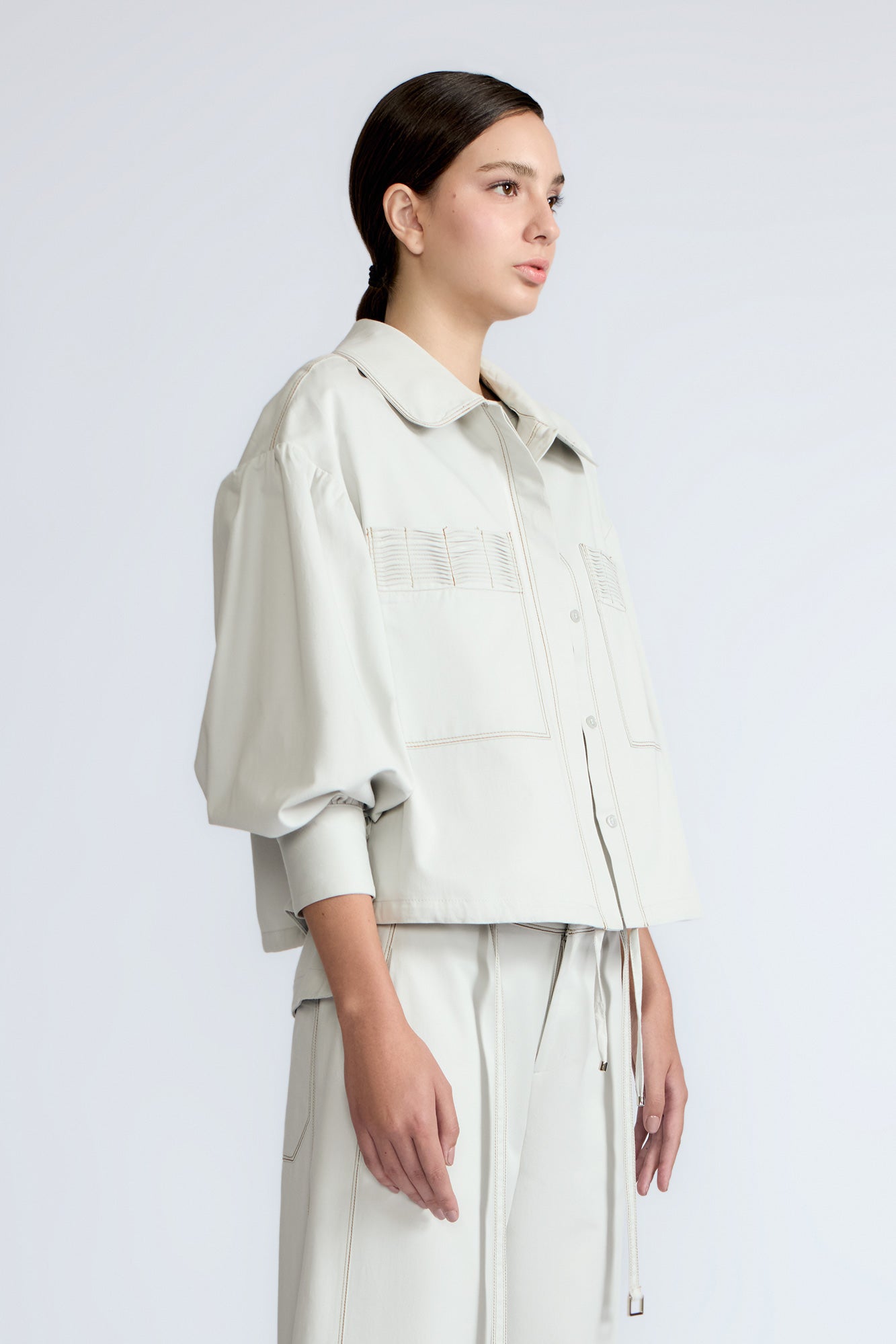 Gwen Jacket in Silver – Cropped cotton jacket with structured pleats, patch pockets, and a modern cut.