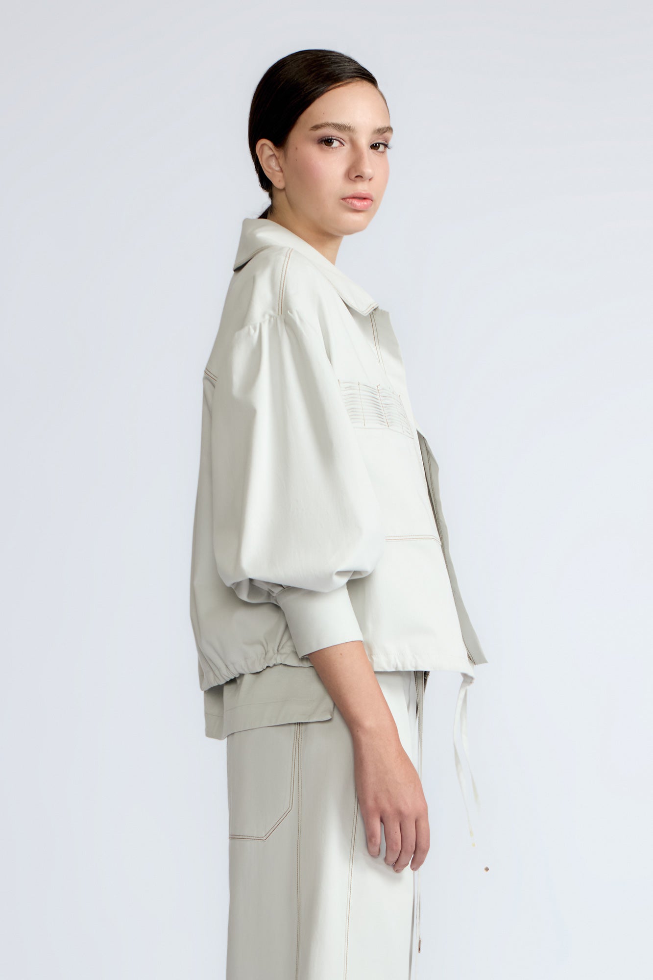 Gwen Jacket in Silver – Cropped cotton jacket with structured pleats, patch pockets, and a modern cut.