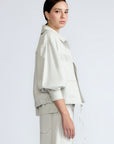 Gwen Jacket in Silver – Cropped cotton jacket with structured pleats, patch pockets, and a modern cut.