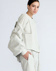 Gwen Jacket in Silver – Cropped cotton jacket with structured pleats, patch pockets, and a modern cut.