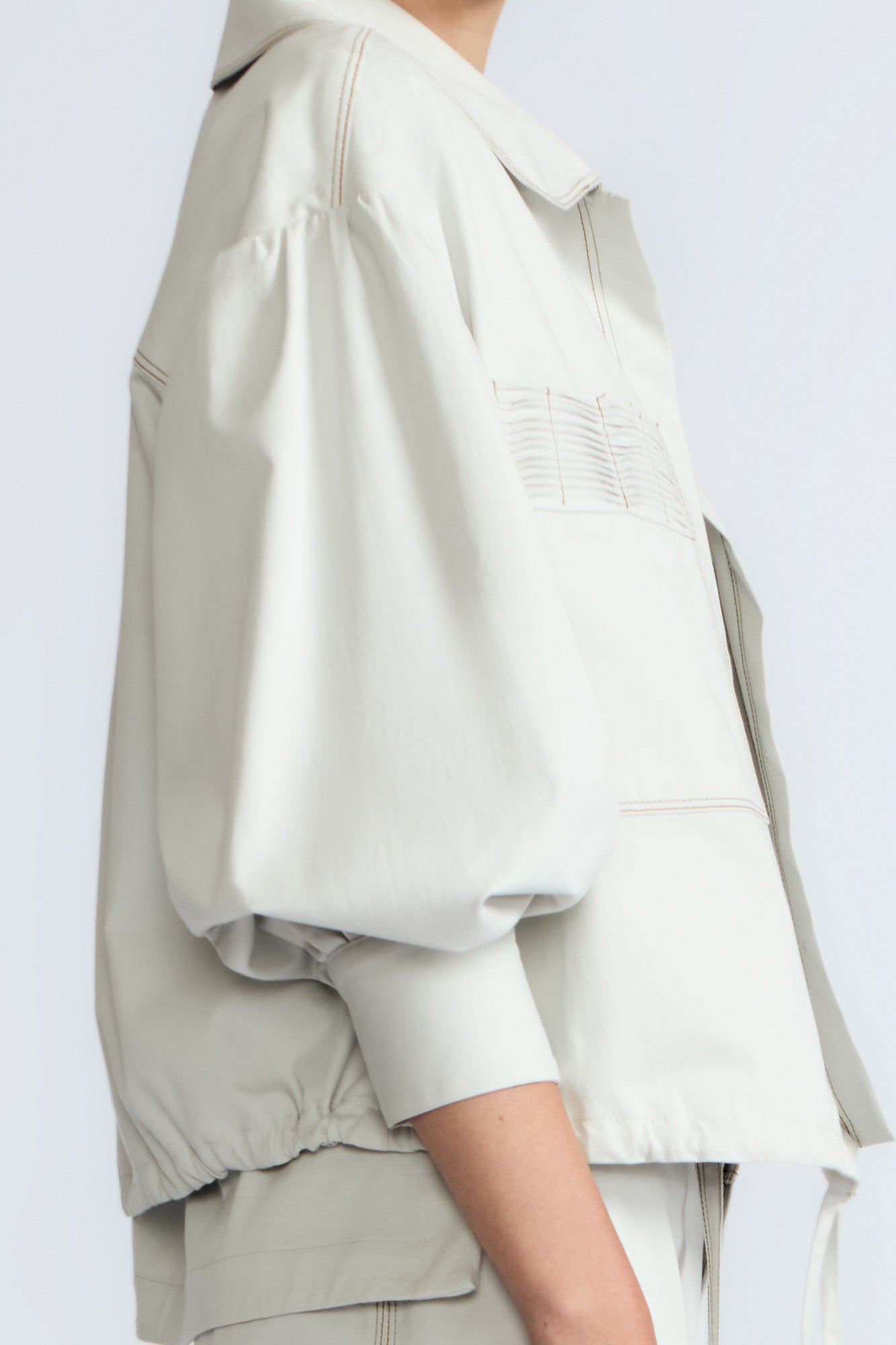 Gwen Jacket in Silver – Cropped cotton jacket with structured pleats, patch pockets, and a modern cut.