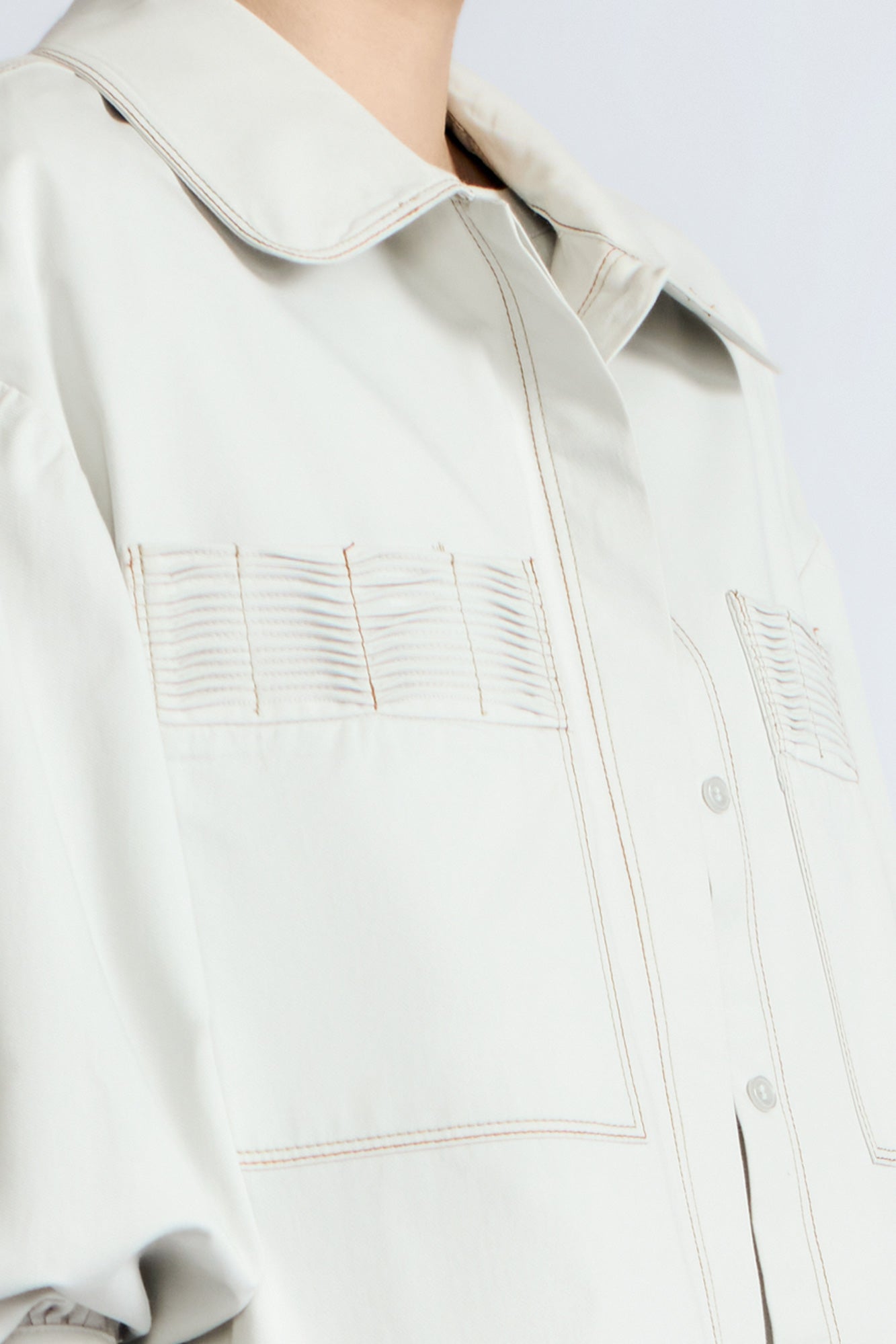 Gwen Jacket in Silver – Cropped cotton jacket with structured pleats, patch pockets, and a modern cut.