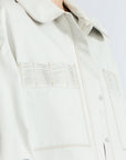 Gwen Jacket in Silver – Cropped cotton jacket with structured pleats, patch pockets, and a modern cut.