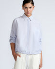 Hebe Blouse in Light Blue Stripes – Relaxed blouse with lapel collar, hidden buttons, asymmetrical hem, and elasticized long sleeves.