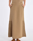 Front view of the straight-cut Indigo Midi Skirt in a sophisticated taupe, showing its diagonal patch pockets.