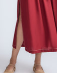 Isidora Dress in Wine – Sleeveless cotton maxi dress with shirt collar, V-neckline, hidden pockets, and tiered silhouette.