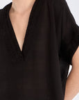 Close-up of the delicate tonal trim detailing on the V-neckline of the black Ivy Blouse.
