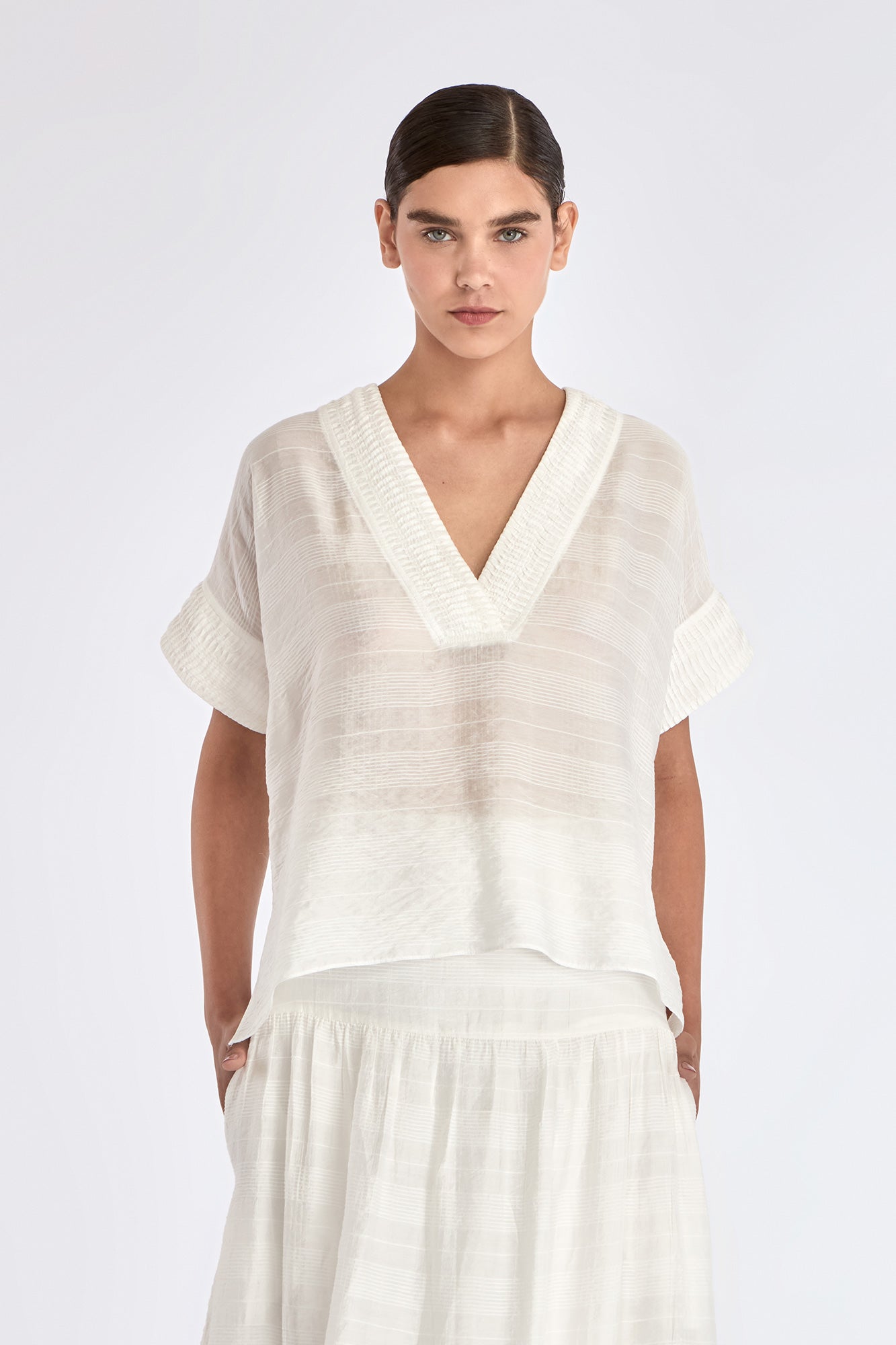 The Ivy Blouse in Off White, featuring its clean V-neckline and refined silhouette.