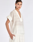Side view of the Off White Ivy Blouse, showcasing the soft drape of its short sleeves.
