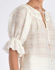 Side view of the Off White Lauren Blouse, showcasing the gathered cuff and relaxed silhouette.