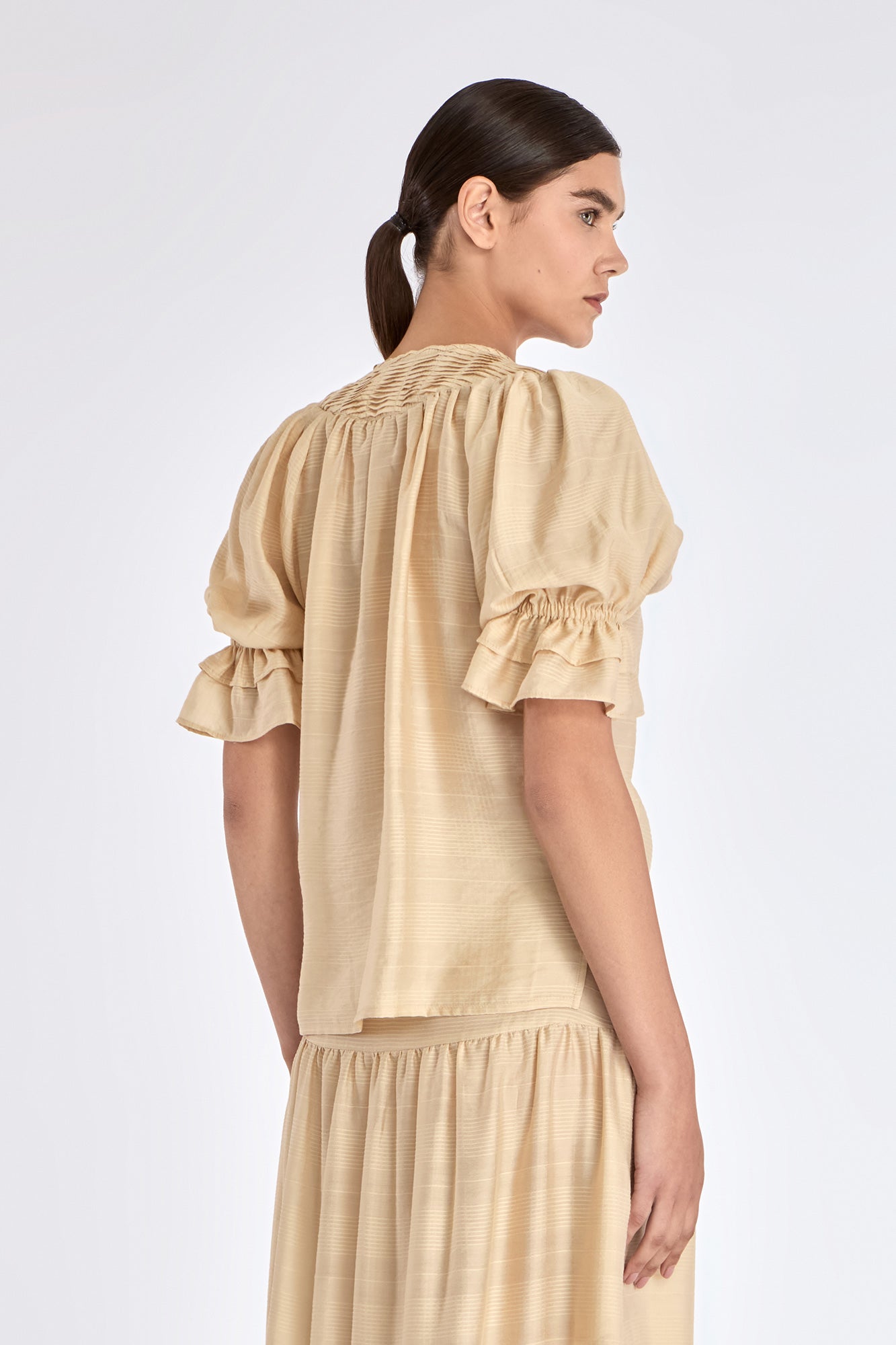 Clean back silhouette of the Lauren Blouse, showing the elegant drape of the fabric.
