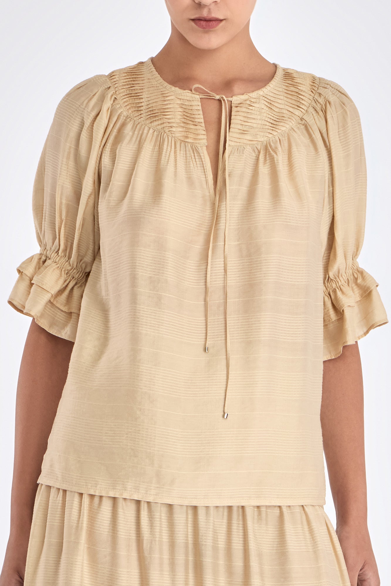 Close-up of the metal-tipped drawstrings and woven texture of the Vanilla Lauren Blouse.