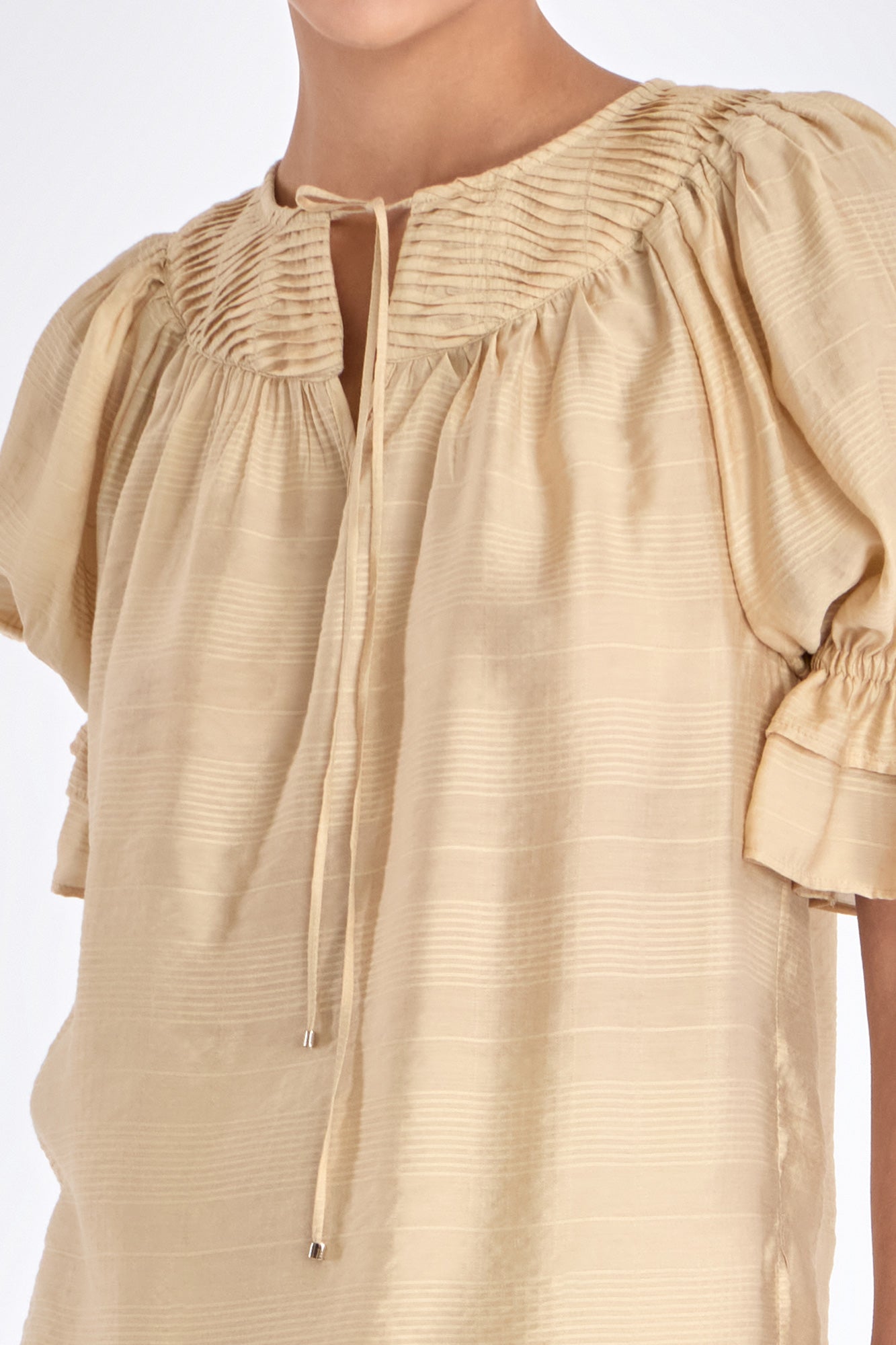 Close-up of the metal-tipped drawstrings and woven texture of the Vanilla Lauren Blouse.