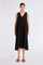 The Lenox Dress in black, styled to showcase its elegant V-neck and voluminous godet skirt.