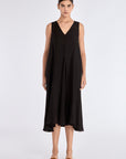 The Lenox Dress in black, styled to showcase its elegant V-neck and voluminous godet skirt.