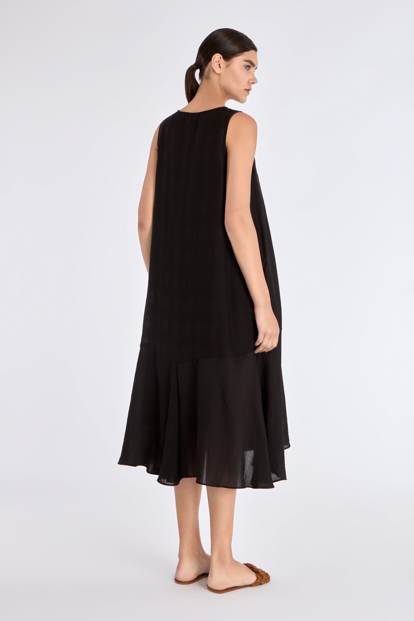 Clean back view of the essential black Lenox Godet Dress.