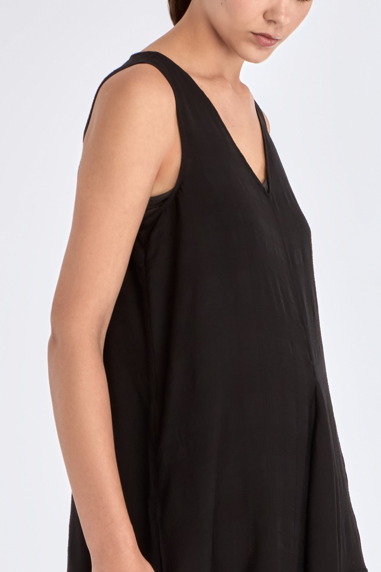 The Lenox Dress in black, styled to showcase its elegant V-neck and voluminous godet skirt.