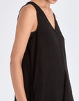 The Lenox Dress in black, styled to showcase its elegant V-neck and voluminous godet skirt.