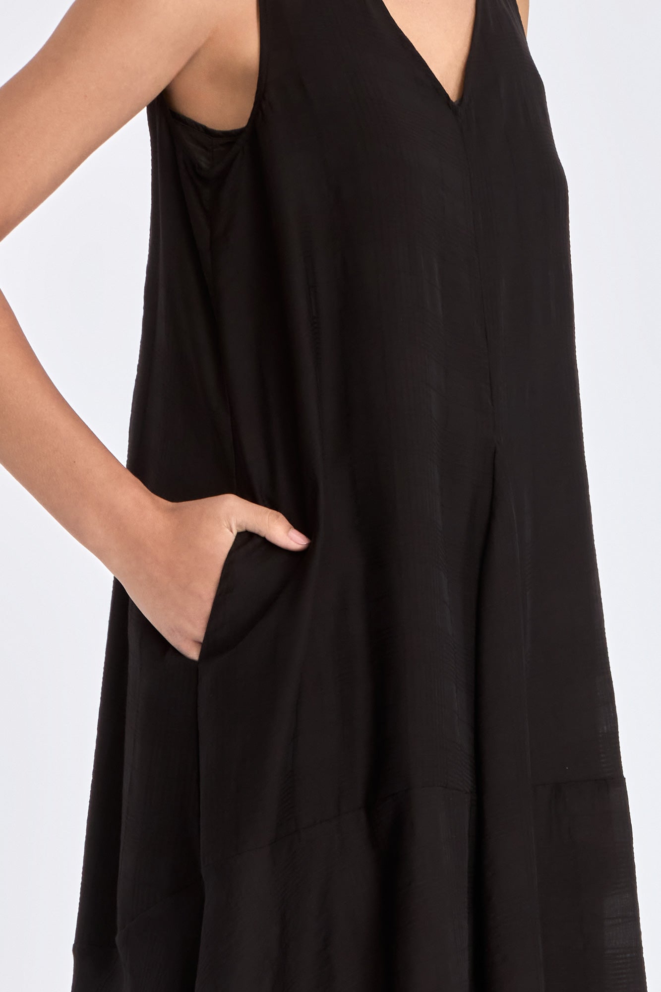 The Lenox Dress in black, styled to showcase its elegant V-neck and voluminous godet skirt.