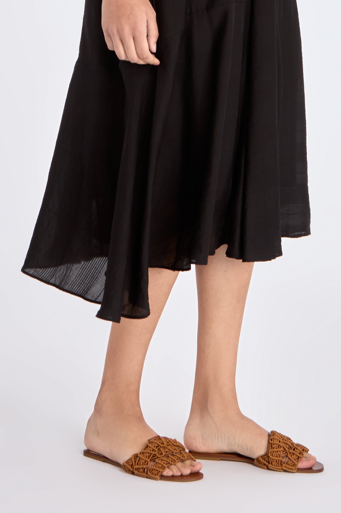 Close-up on the lower part of the Lenox Dress, detailing the godet panel construction and fluid fabric.