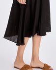 Close-up on the lower part of the Lenox Dress, detailing the godet panel construction and fluid fabric.