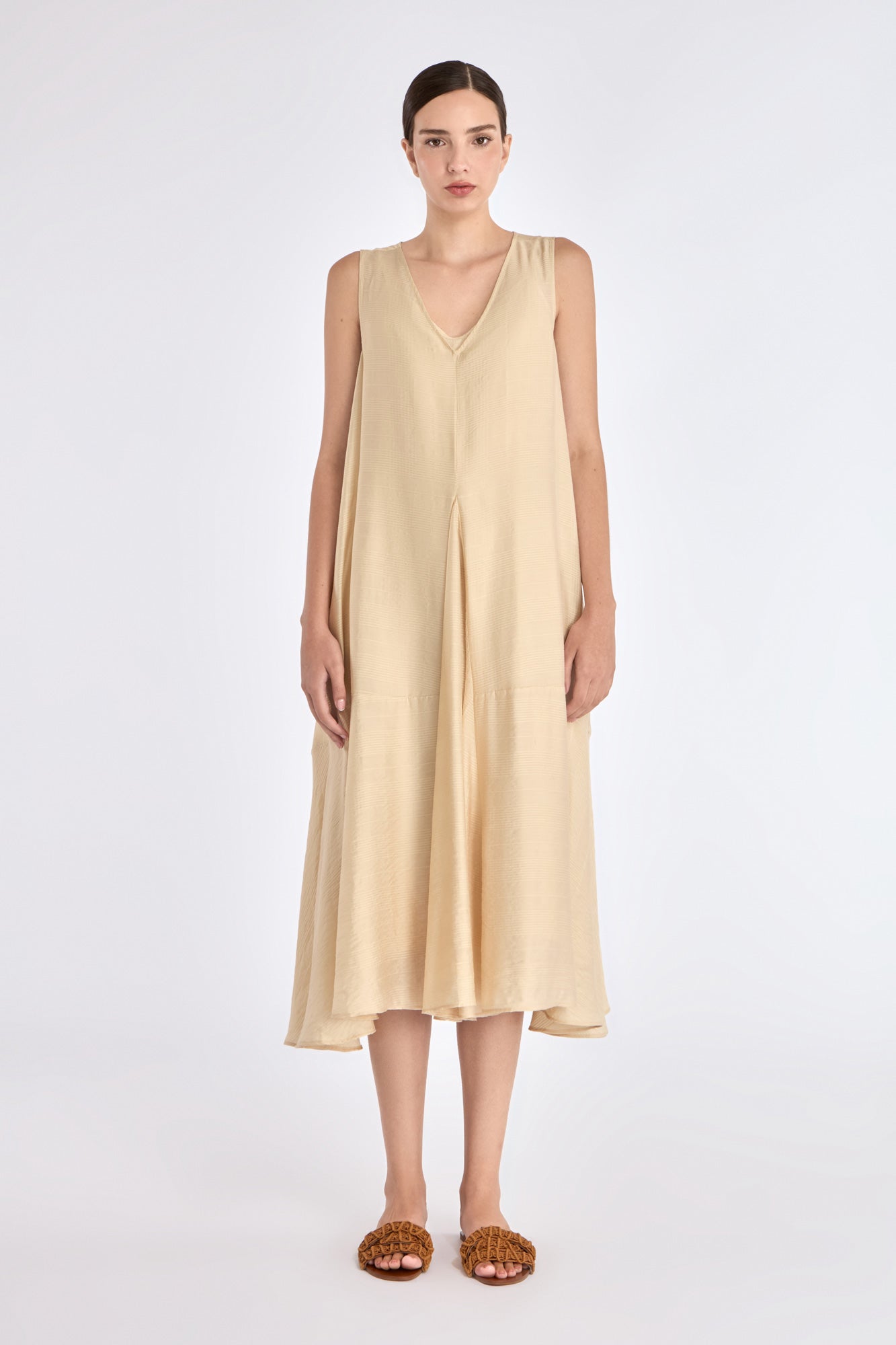 Front view of the Lenox Dress in Vanilla, showcasing its V-neckline and flowing godet skirt.