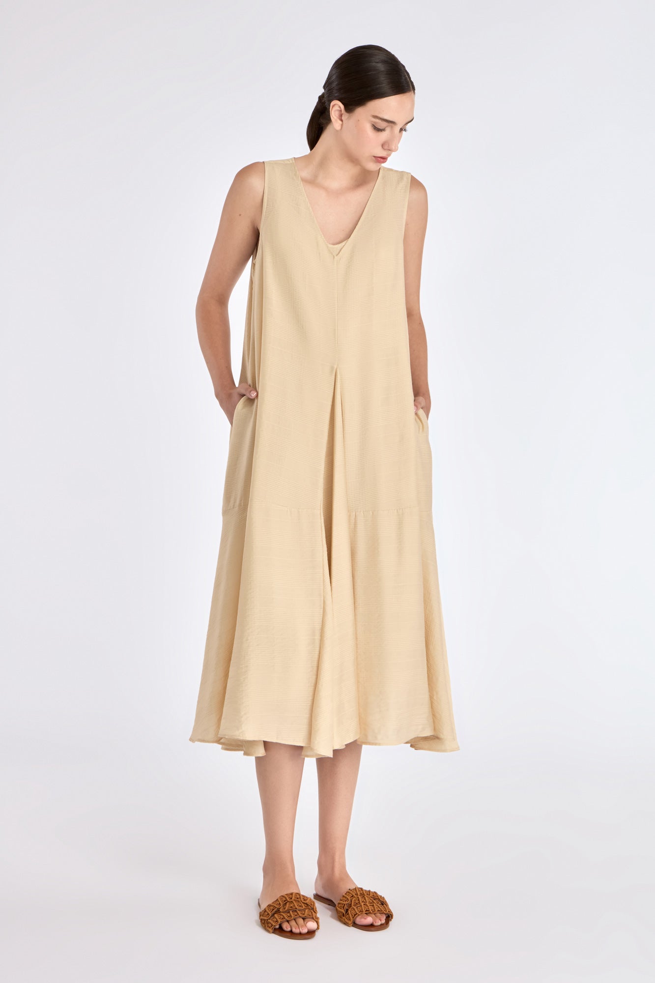 Front view of the Lenox Dress in Vanilla, showcasing its V-neckline and flowing godet skirt.