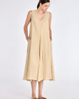 Front view of the Lenox Dress in Vanilla, showcasing its V-neckline and flowing godet skirt.