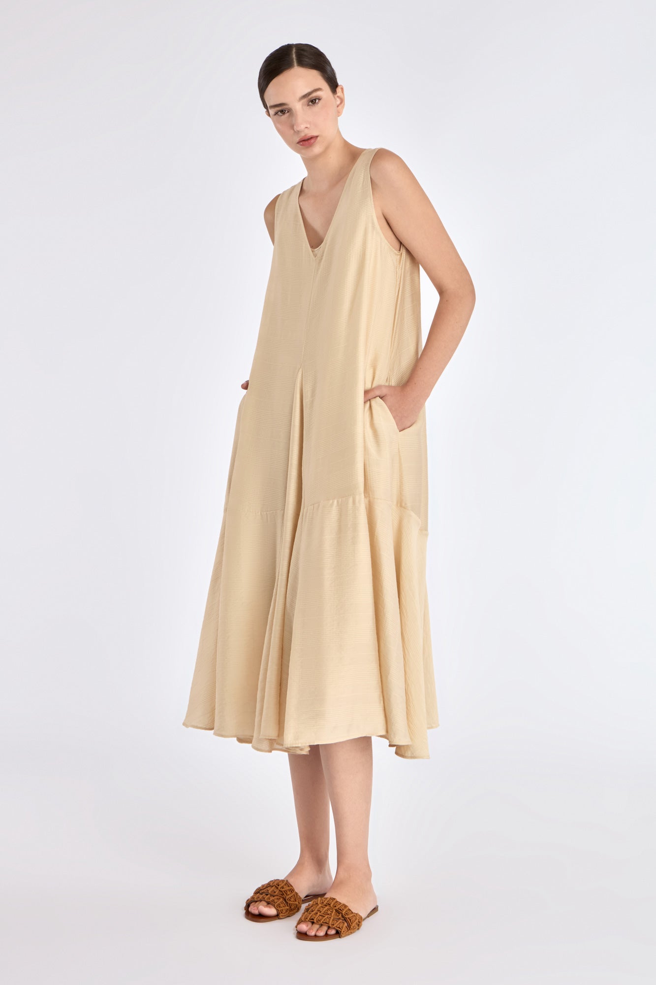 Front view of the Lenox Dress in Vanilla, showcasing its V-neckline and flowing godet skirt.