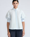 Lina Blouse in Light Blue – Cotton shirt with shirt collar, hidden button closure, ¾ balloon sleeves, and elastic cuffs.
