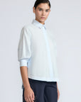 Lina Blouse in Light Blue – Cotton shirt with shirt collar, hidden button closure, ¾ balloon sleeves, and elastic cuffs.