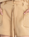Lira Short in Camel – Linen mid-rise shorts with patch pockets, belt with metal tips, and tone-on-tone trims.