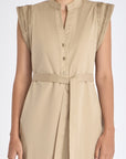 Detail shot of the V-neckline, metal button, and stretch cotton fabric of the Ecru Maki Dress.