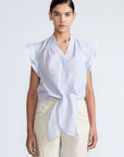 Oriana Blouse in Light Blue Stripes – Cotton blouse with V-neck, Neru collar, ruffled sleeves, appliqué trim, and tie-front hem.