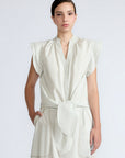 Oriana Blouse in Silver – Cotton blouse with V-neckline, Neru collar, ruffled sleeve details, tie hem, and appliqué embellishment.