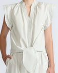 Oriana Blouse in Silver – Cotton blouse with V-neckline, Neru collar, ruffled sleeve details, tie hem, and appliqué embellishment.