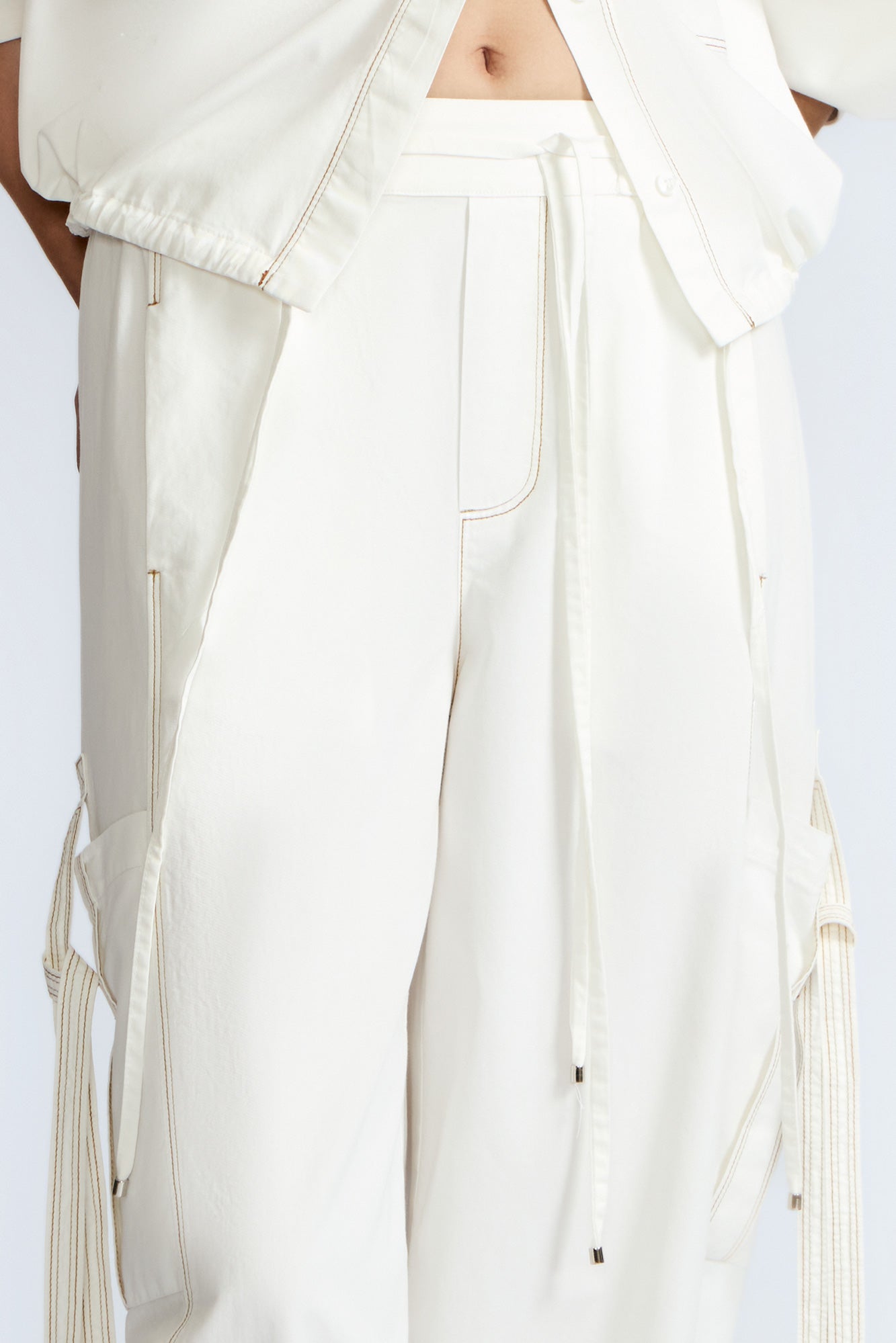 Paloma Pant in Off White – Relaxed cotton pants with patch pockets, contrast stitching, and side ties for a chic silhouette.