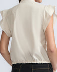 Pria Blouse in Prestine – Elegant sleeveless blouse in pima cotton with tonal V-neck, Greca trim, ruffle detail, and hem with pullers.