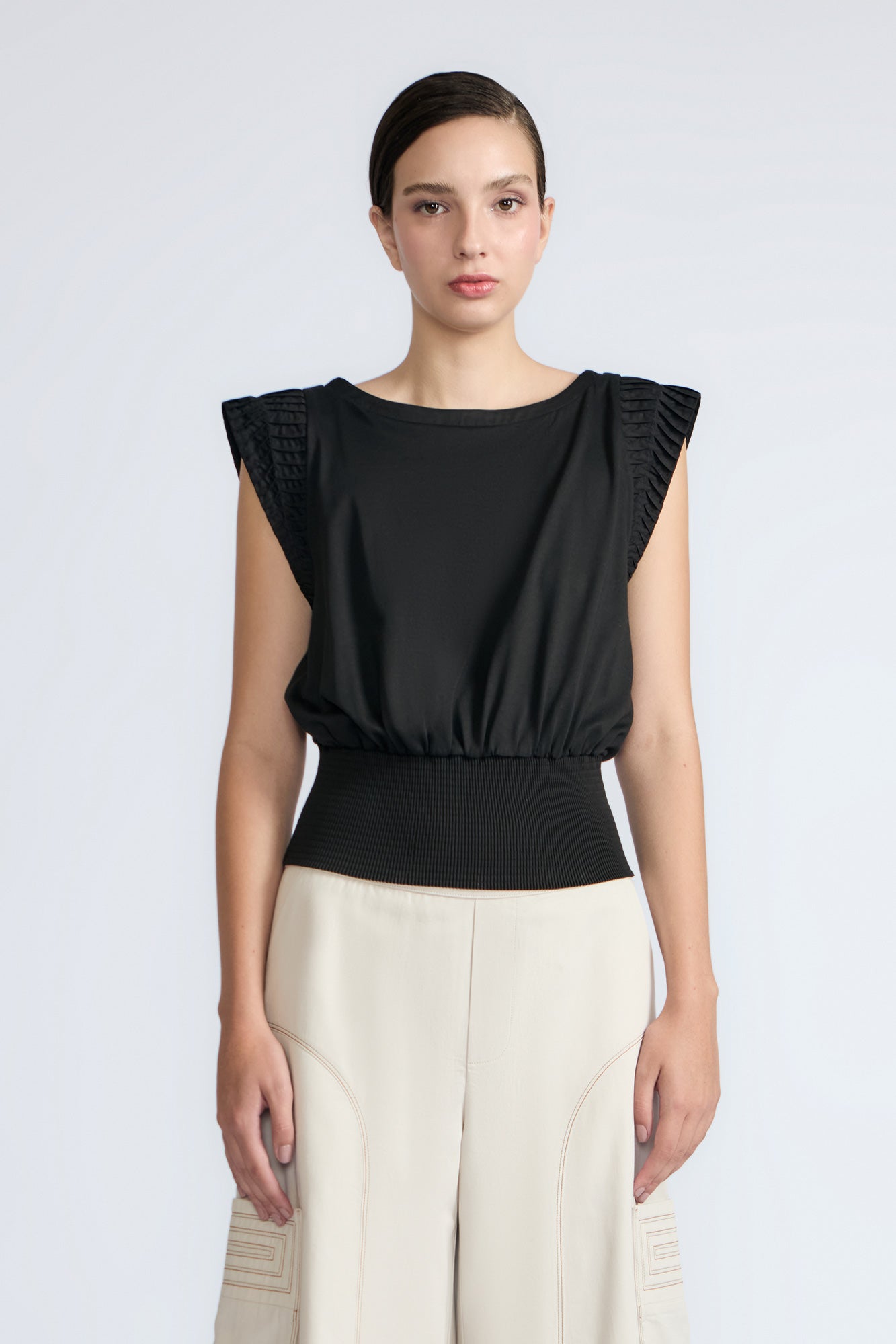 Selena Top in Black – Sleeveless cotton top with round neckline, semi-ruffled sleeves, and elasticized waistband.
