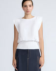 Selena Top in White – Soft cotton sleeveless top with round collar, ruffled arm details, and a gently cinched waist.