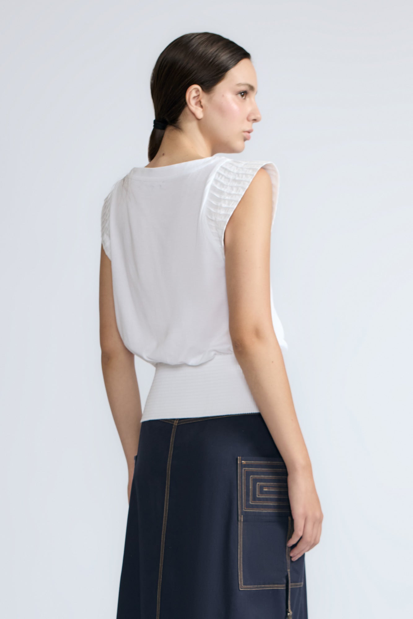 Selena Top in White – Soft cotton sleeveless top with round collar, ruffled arm details, and a gently cinched waist.