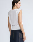 Selena Top in White – Soft cotton sleeveless top with round collar, ruffled arm details, and a gently cinched waist.