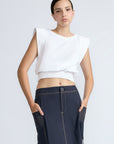 Selena Top in White – Soft cotton sleeveless top with round collar, ruffled arm details, and a gently cinched waist.