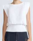 Selena Top in White – Soft cotton sleeveless top with round collar, ruffled arm details, and a gently cinched waist.