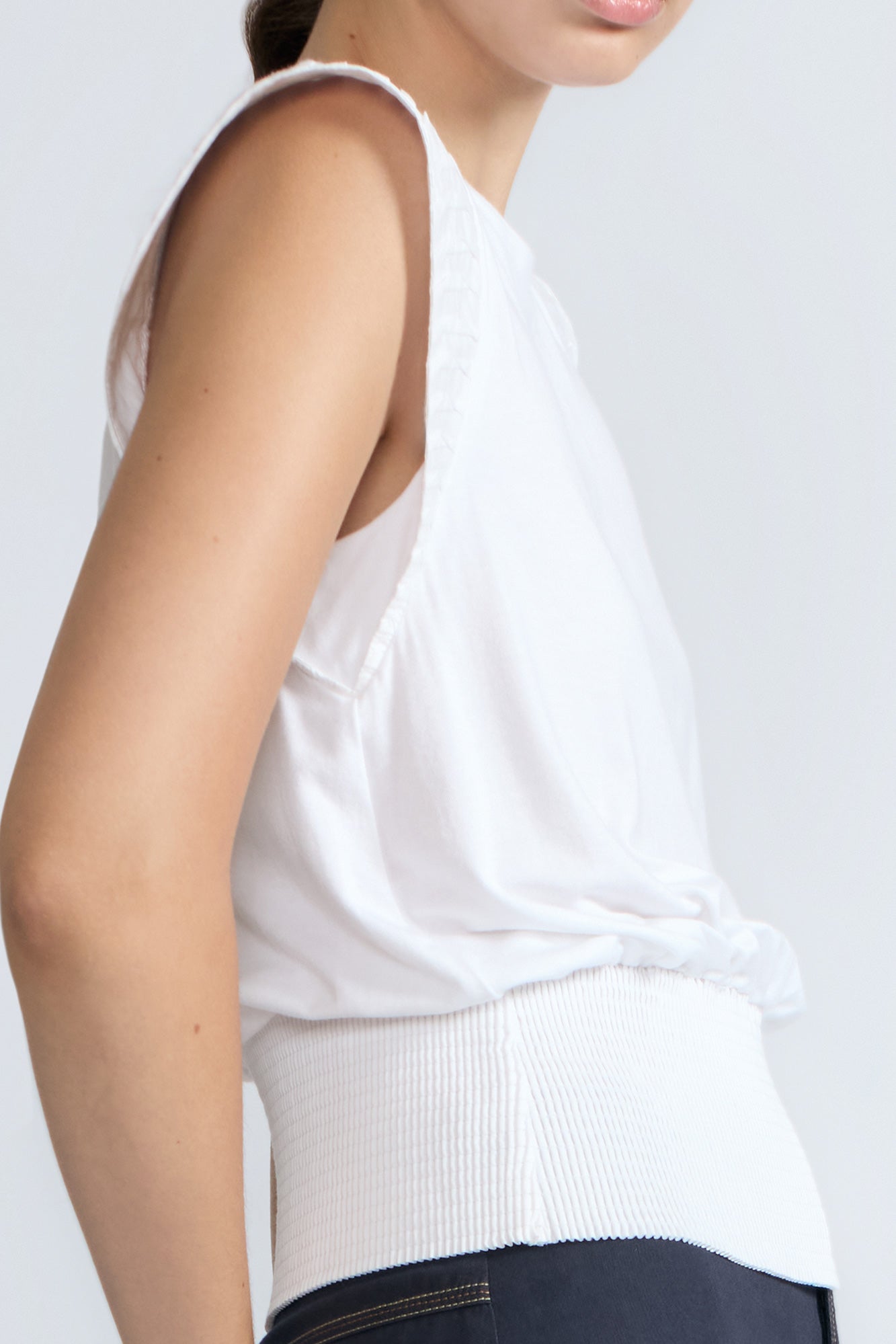 Selena Top in White – Soft cotton sleeveless top with round collar, ruffled arm details, and a gently cinched waist.