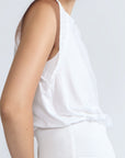 Selena Top in White – Soft cotton sleeveless top with round collar, ruffled arm details, and a gently cinched waist.
