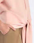 Close-up of the adjustable tie-hem and the textured linen blend fabric of the Rose Shelby Blouse.