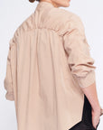 Detail shot of the adjustable drawstring on the shoulder, a signature of the Camel Star Blouse's transformative design.