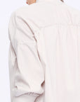 Close-up of the innovative drawstring mechanism on the shoulder of the Sand Star Blouse, a detail of considered design.