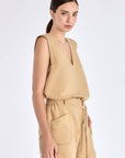 Side view of the Camel Valencia Blouse, with a focus on the adjustable buckle at the hem.